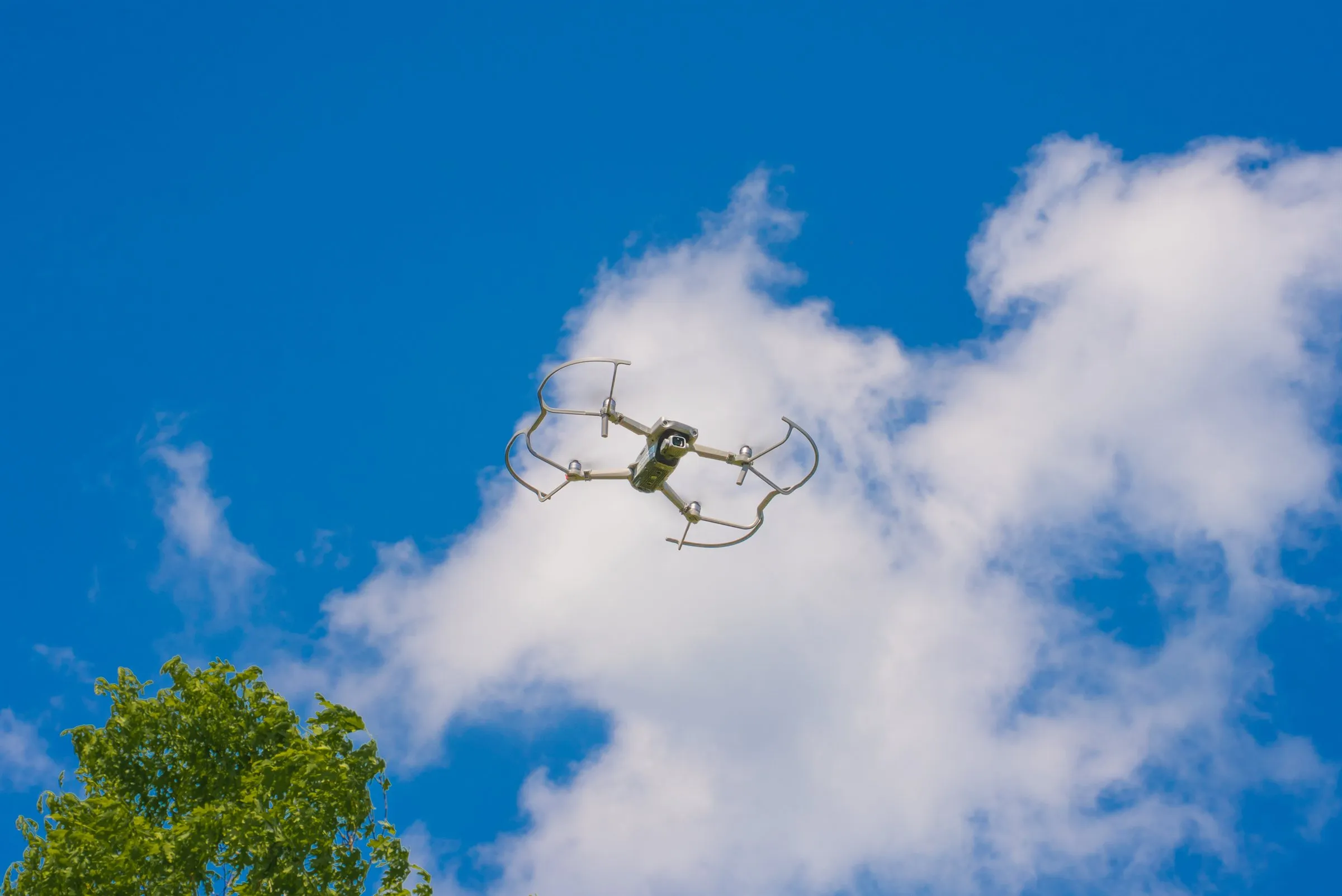 DJI Air 2S drone flying against a blue sky with white clouds