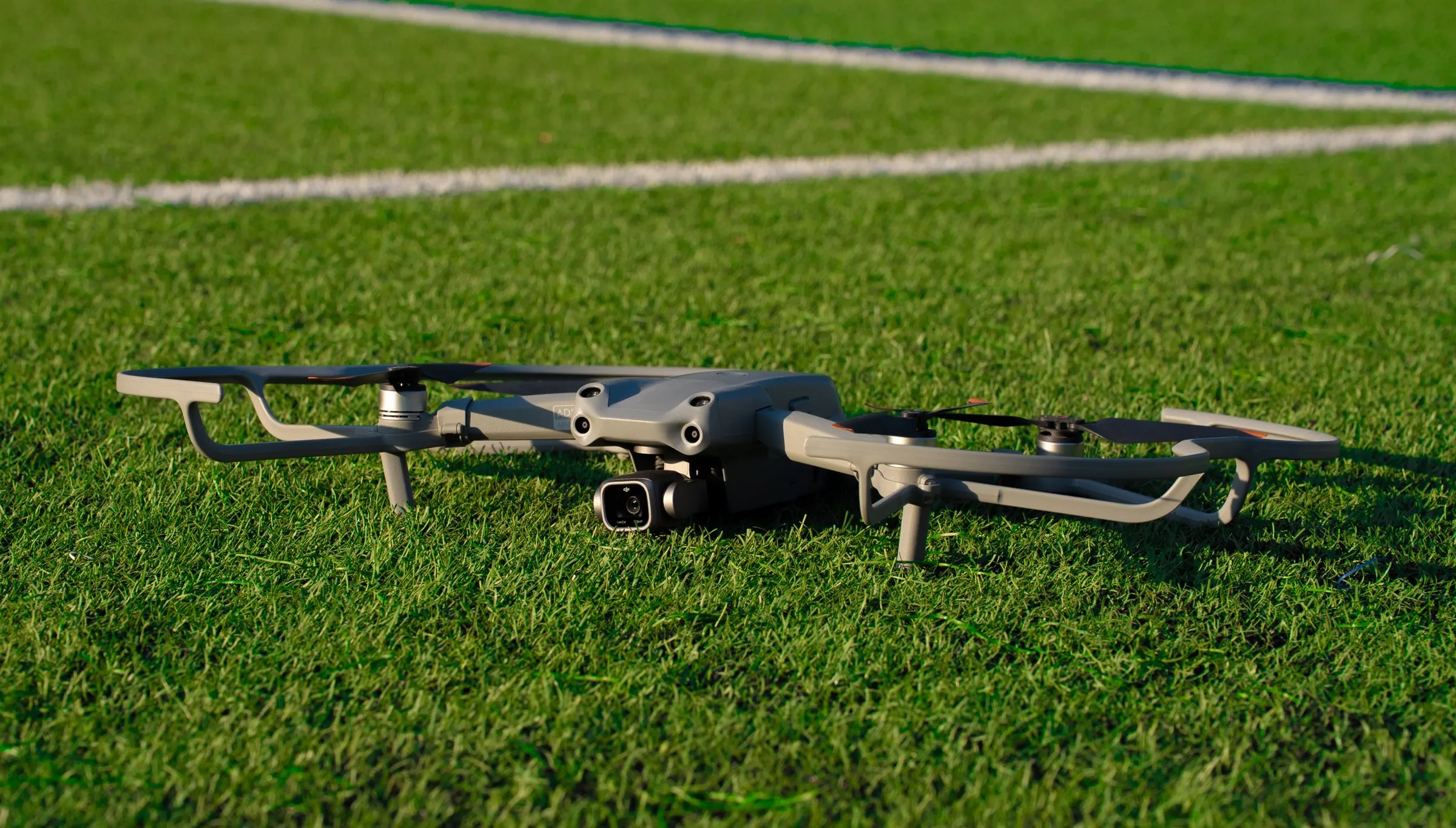 DJI Air 2S drone resting on green grass, arms unfolded