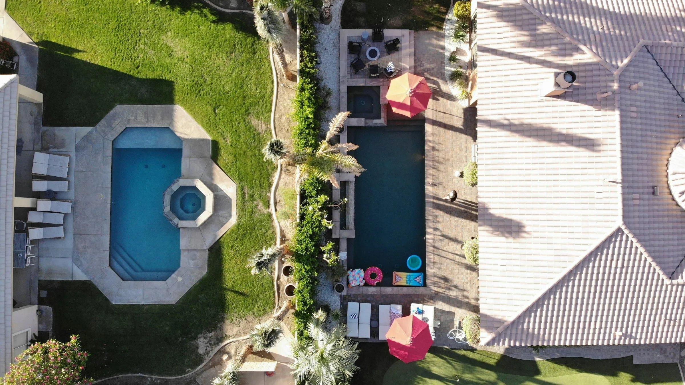 Overhead view of a house with a pool, patio and lawn